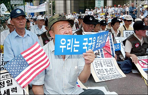 23일 서울 광화문에서 열린 국군격려국민대회 참가자들이 '우리는 국군을 믿습니다'라고 적힌 플래카드와 성조기를 들고 있다. 